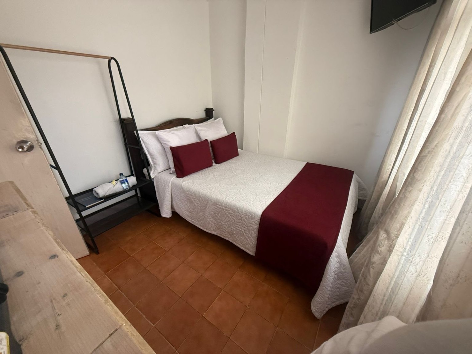 Habitación de Maraná con cama doble y detalles color vino